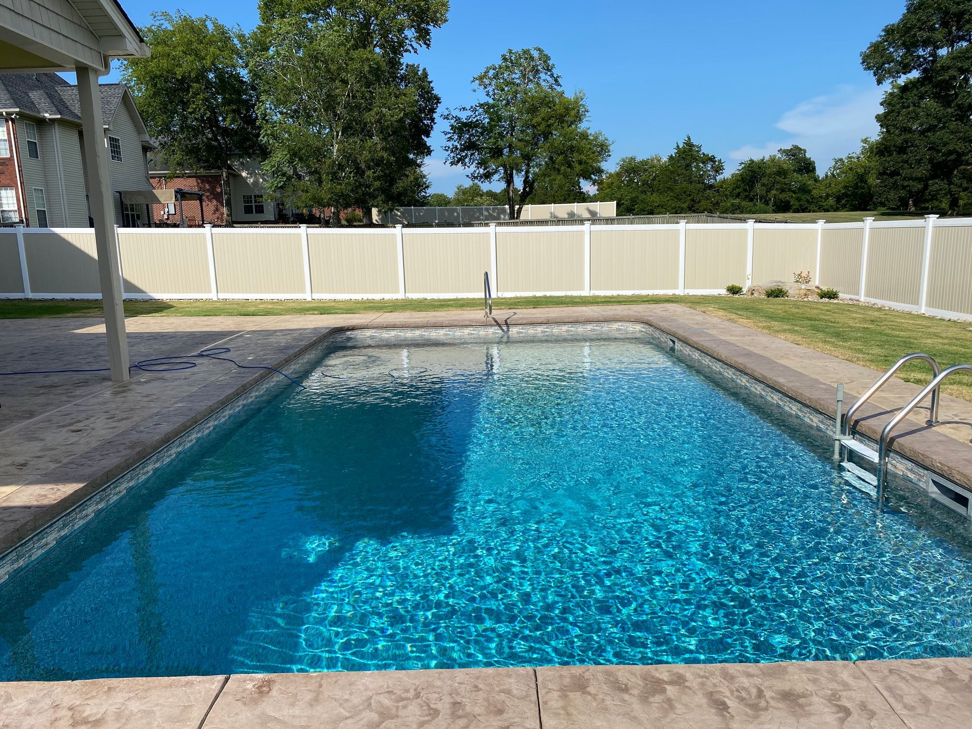 A large swimming pool with a white fence around it