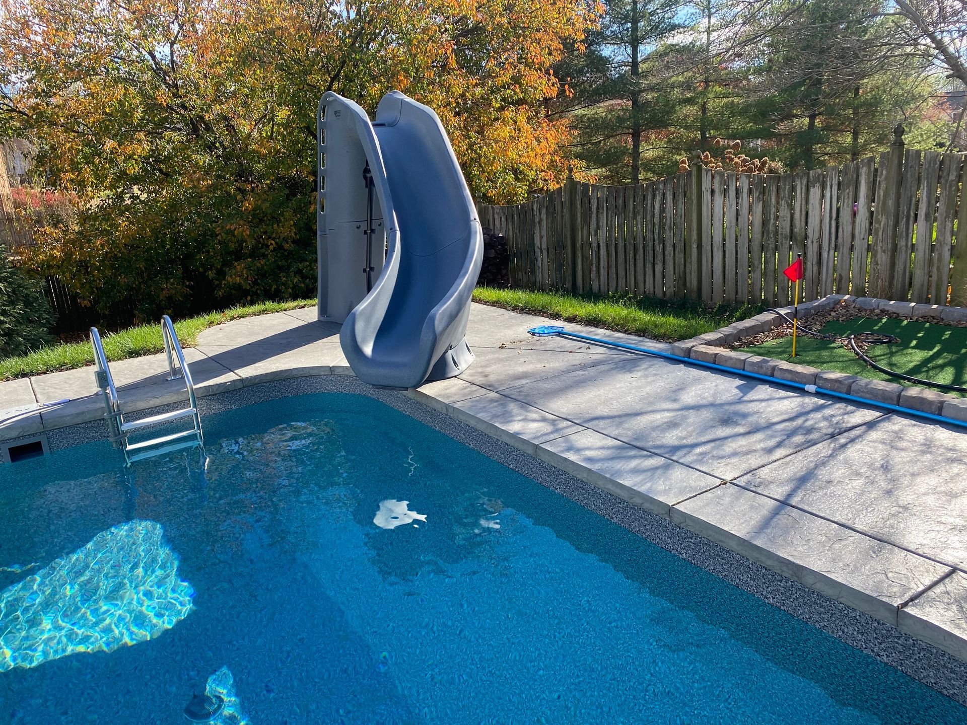 A swimming pool with a slide attached to the side of it.