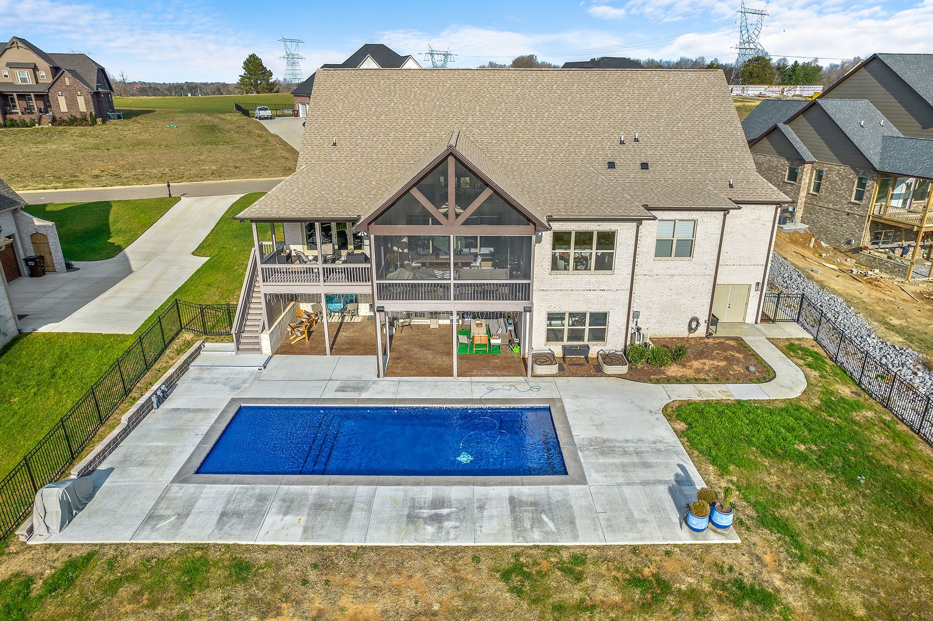 An aerial view of a house with a large swimming pool in the backyard.