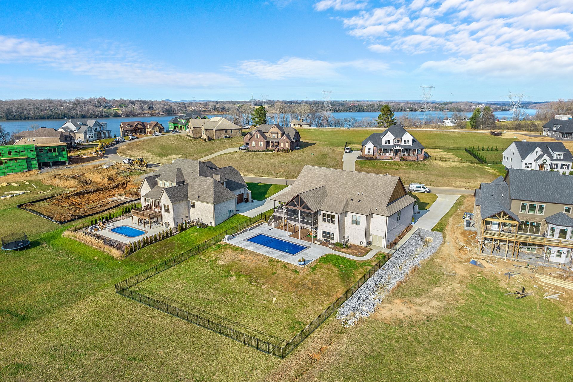 An aerial view of a residential area with houses and a pool.