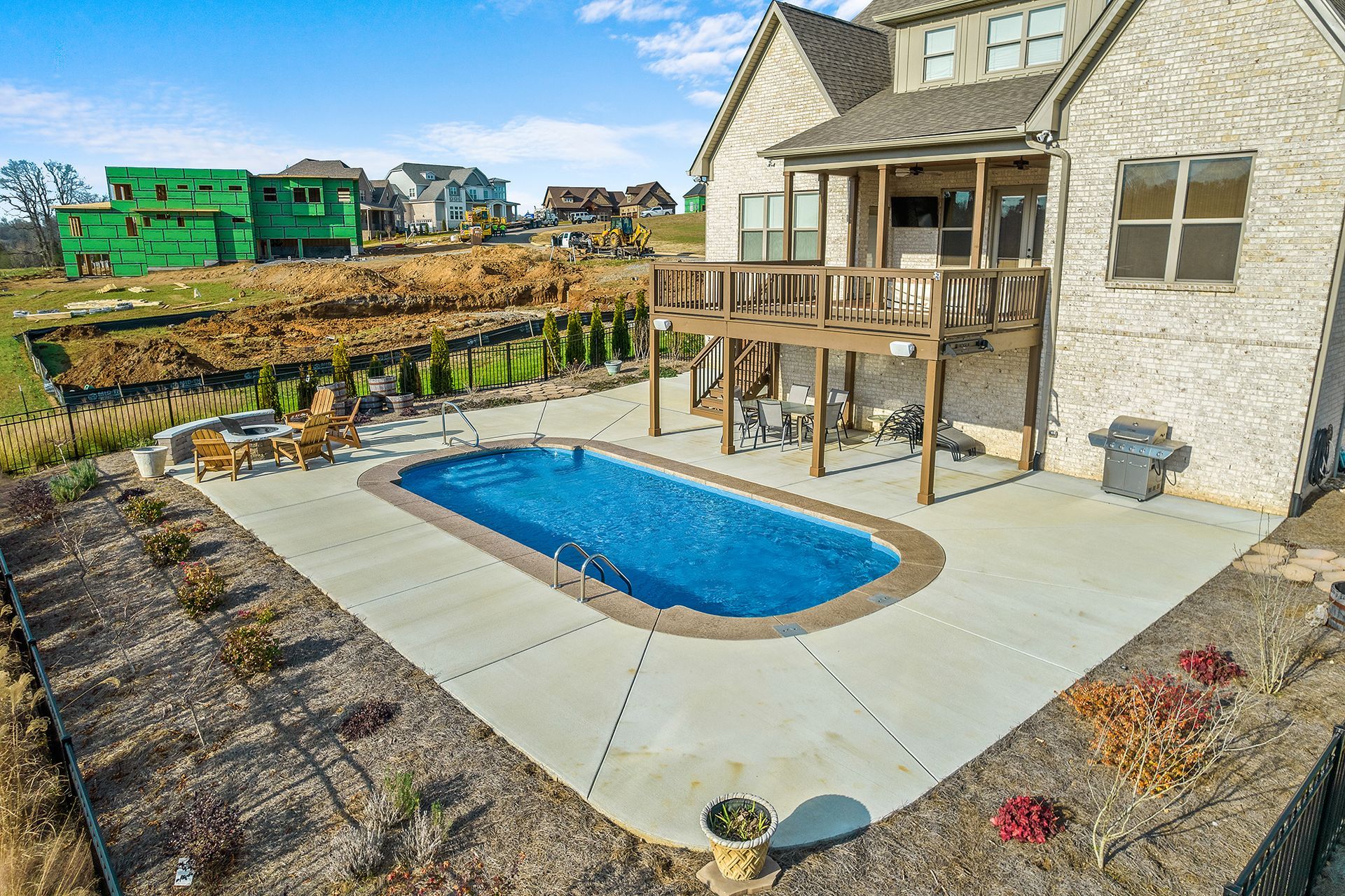 An aerial view of a house with a large swimming pool in the backyard.