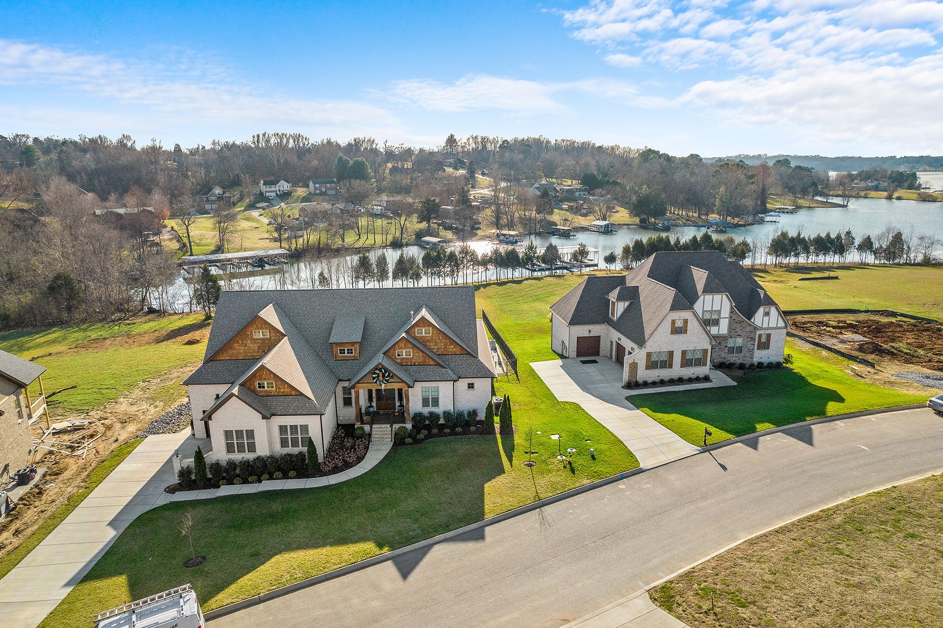 An aerial view of a residential area with houses and a lake in the background.