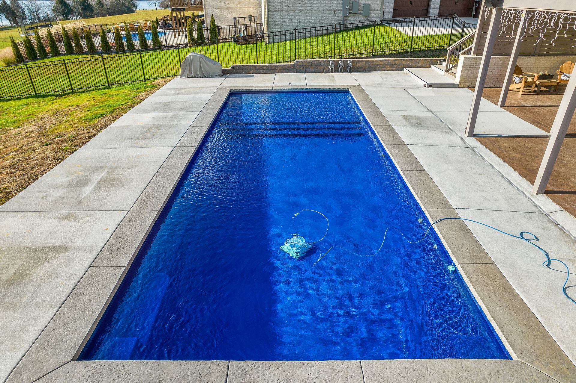 A large blue swimming pool is sitting on top of a concrete patio.