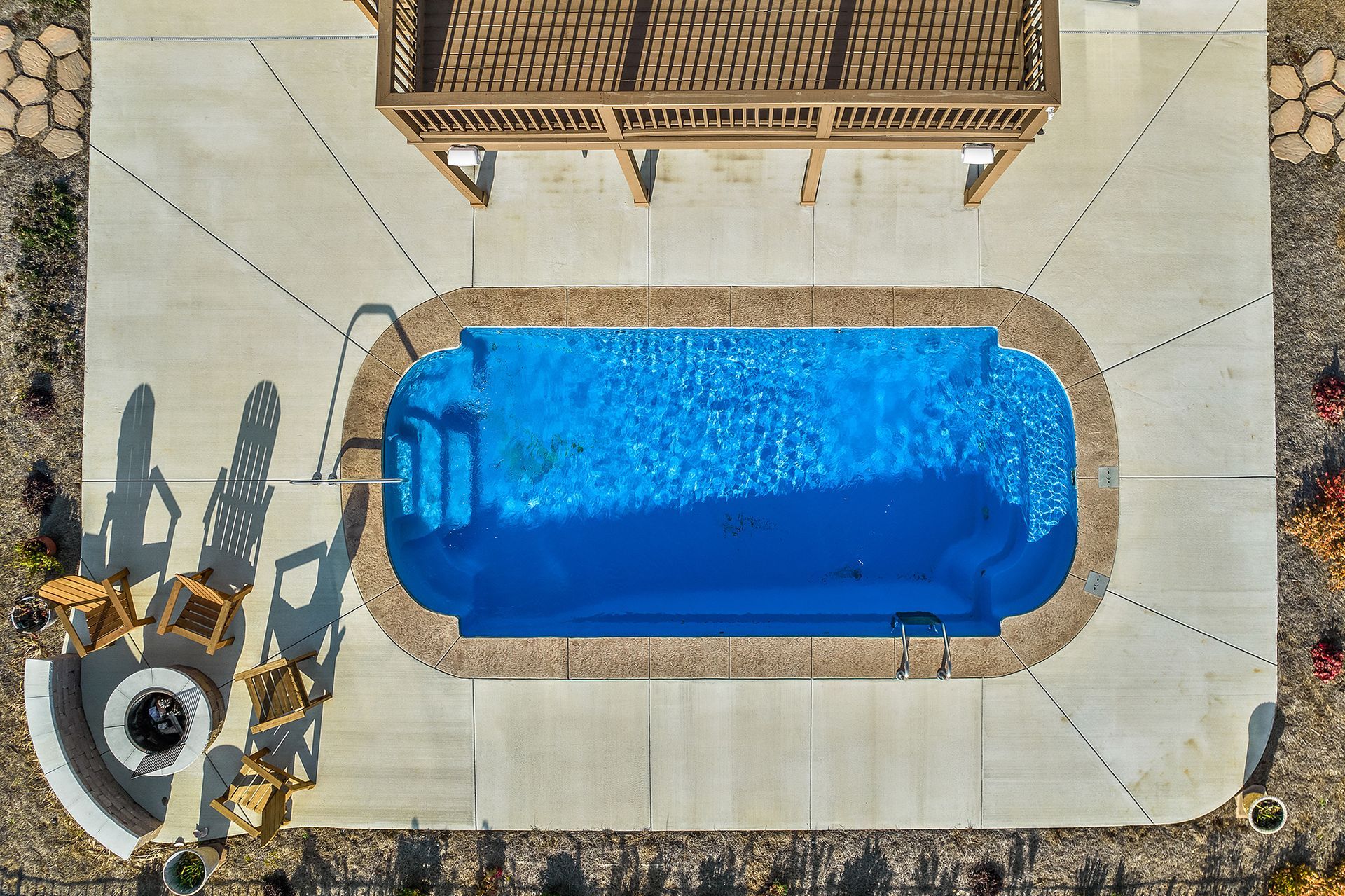 An aerial view of a swimming pool with a gazebo in the background