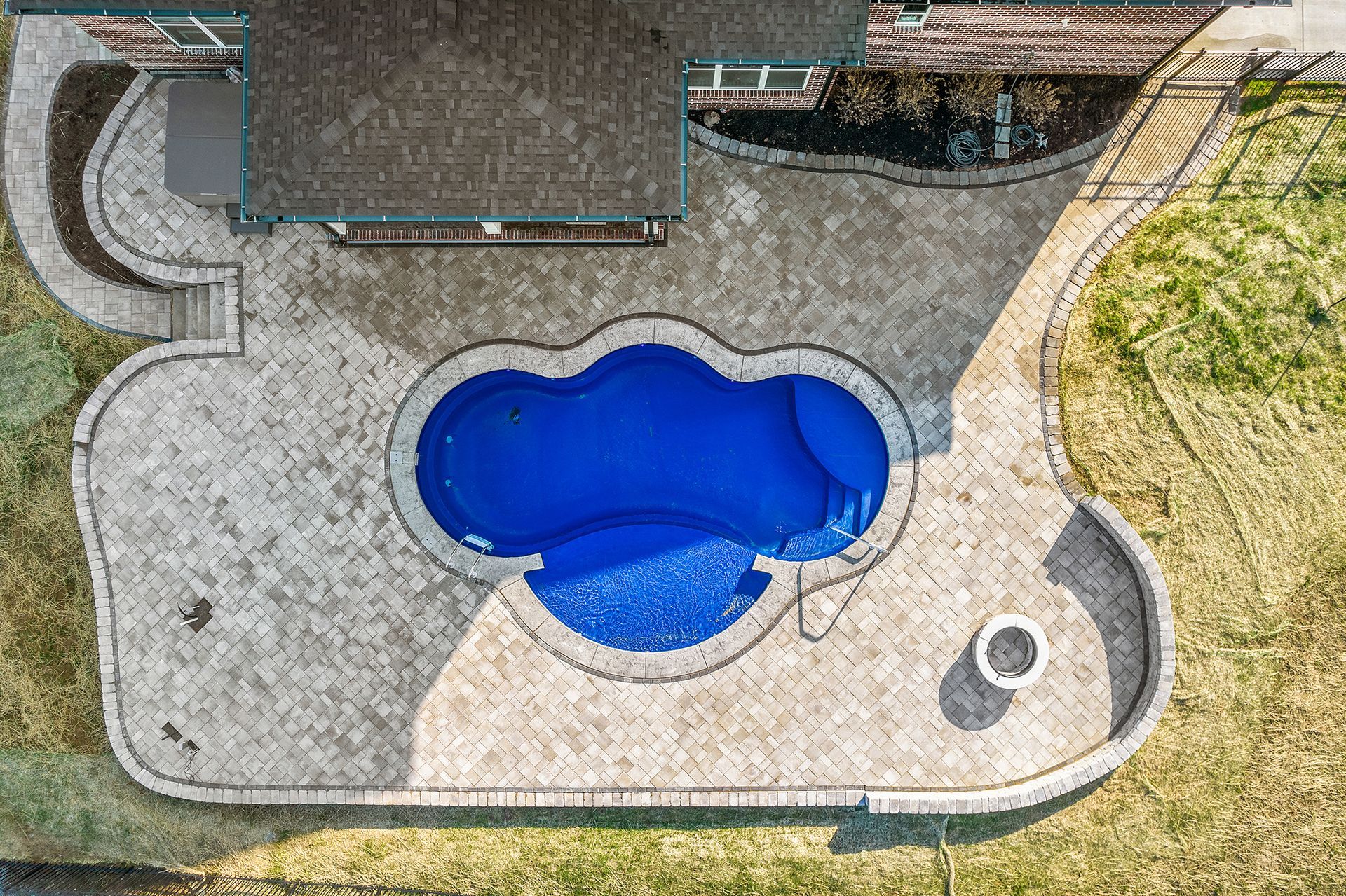 An aerial view of a swimming pool in a backyard.