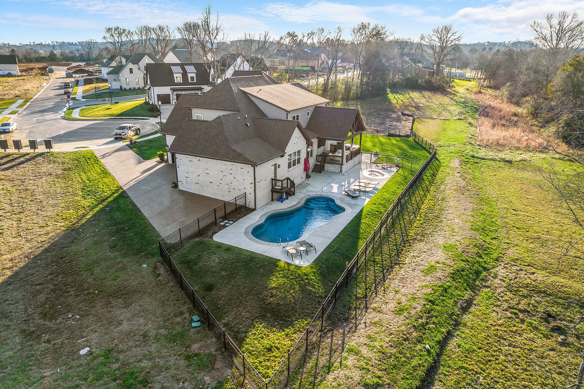 An aerial view of a house with a large pool in the backyard.