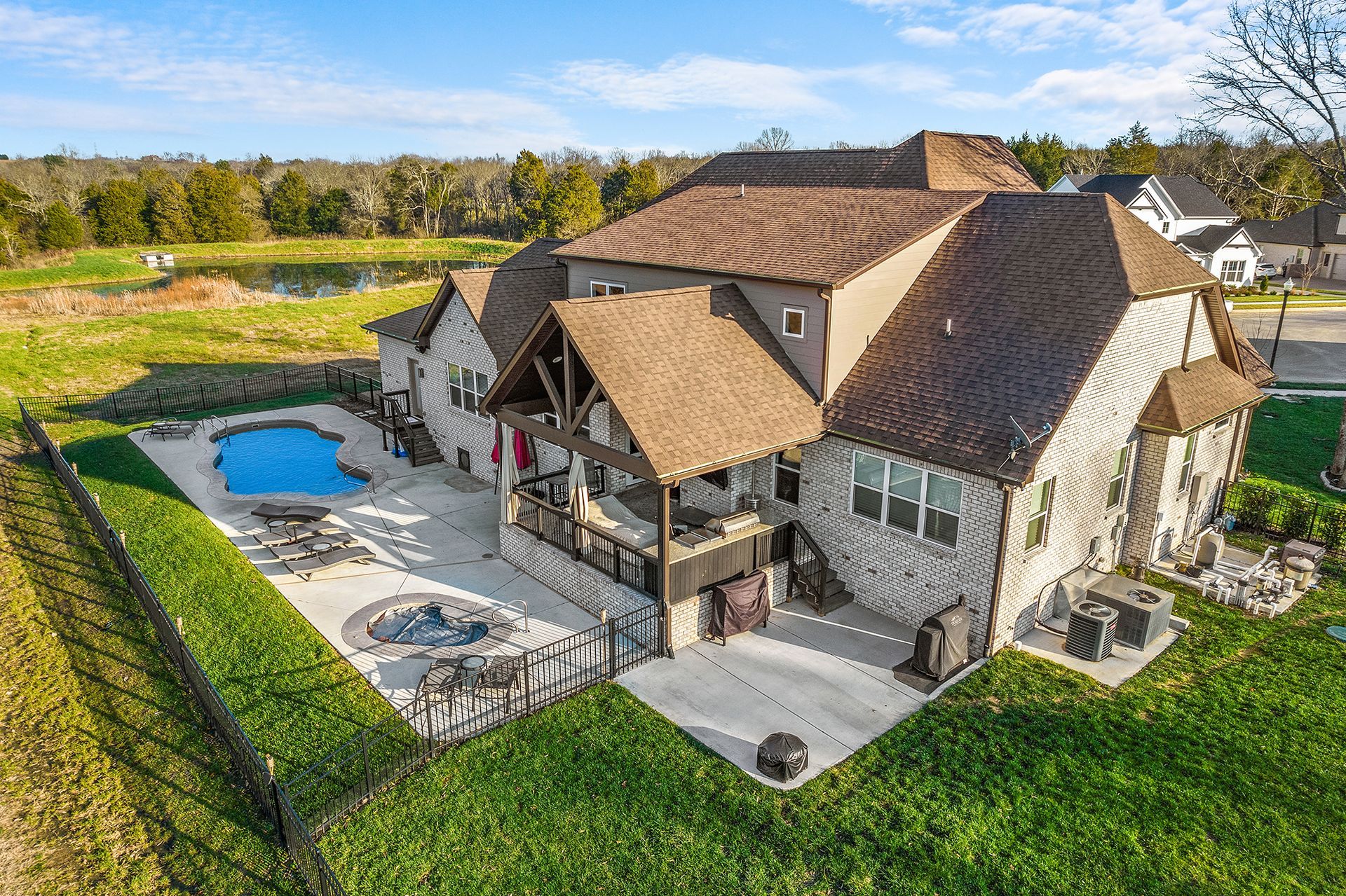 An aerial view of a large house with a pool in the backyard.