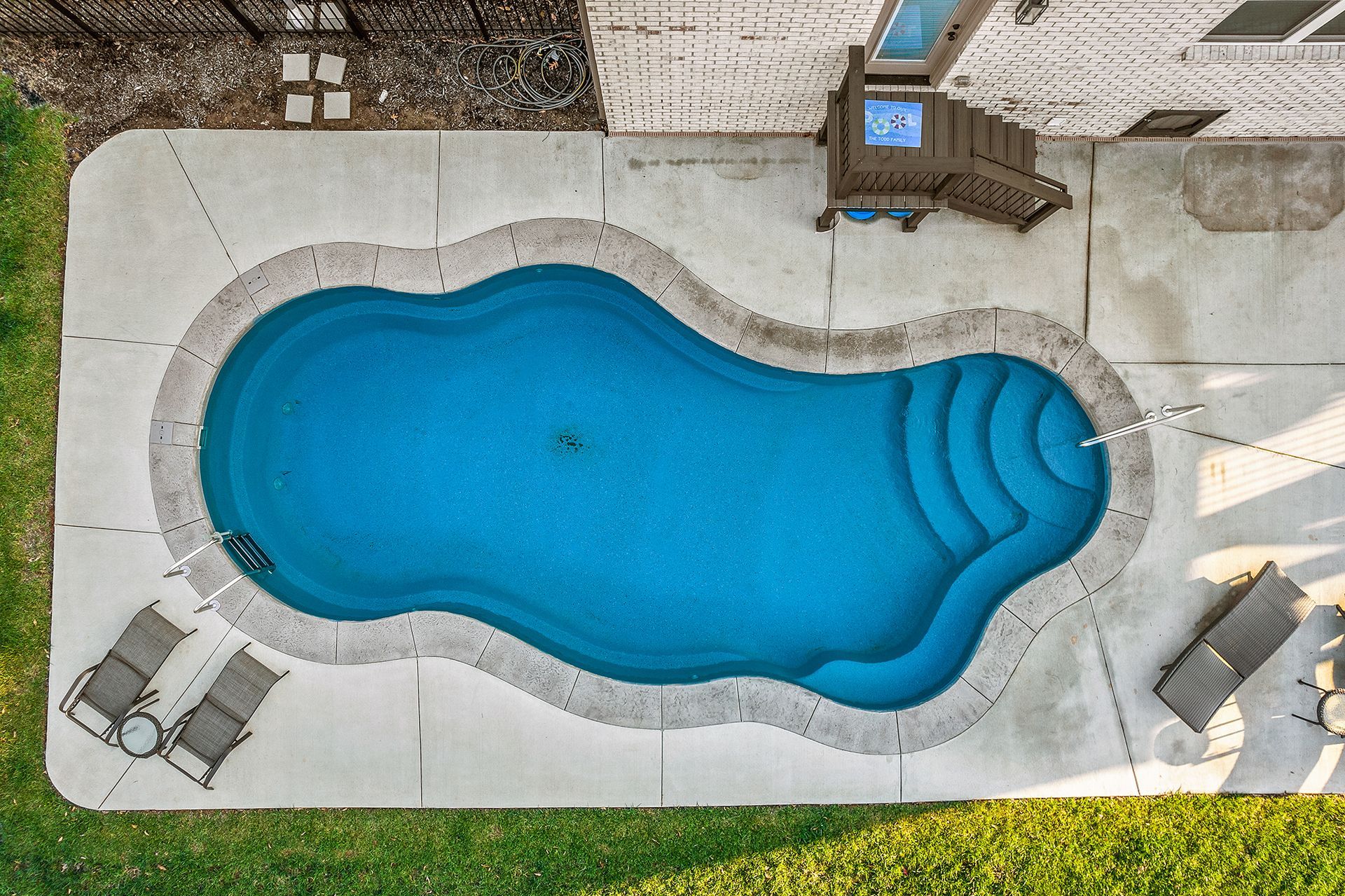 An aerial view of a large swimming pool in a backyard.