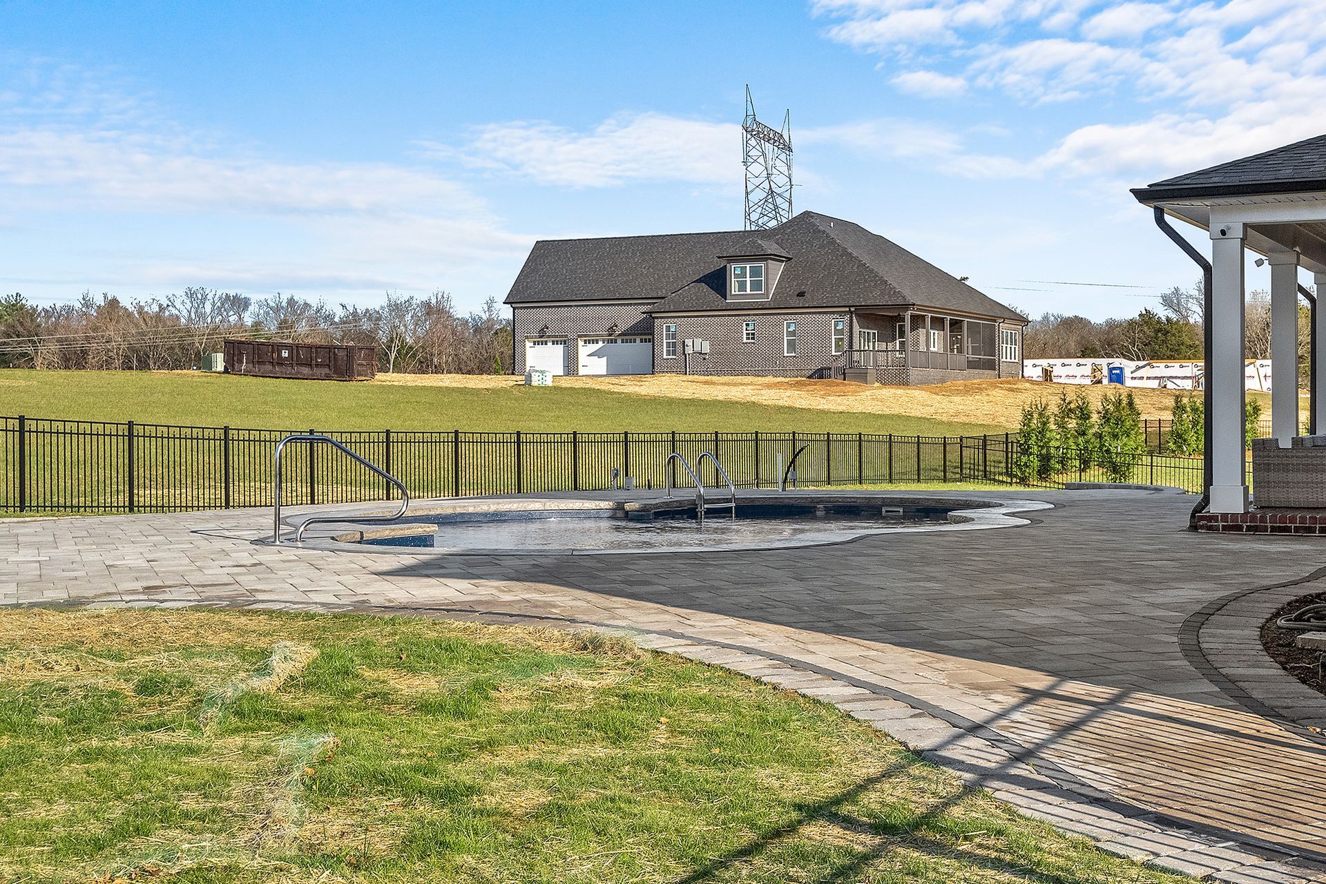 A large house is sitting on top of a lush green field.