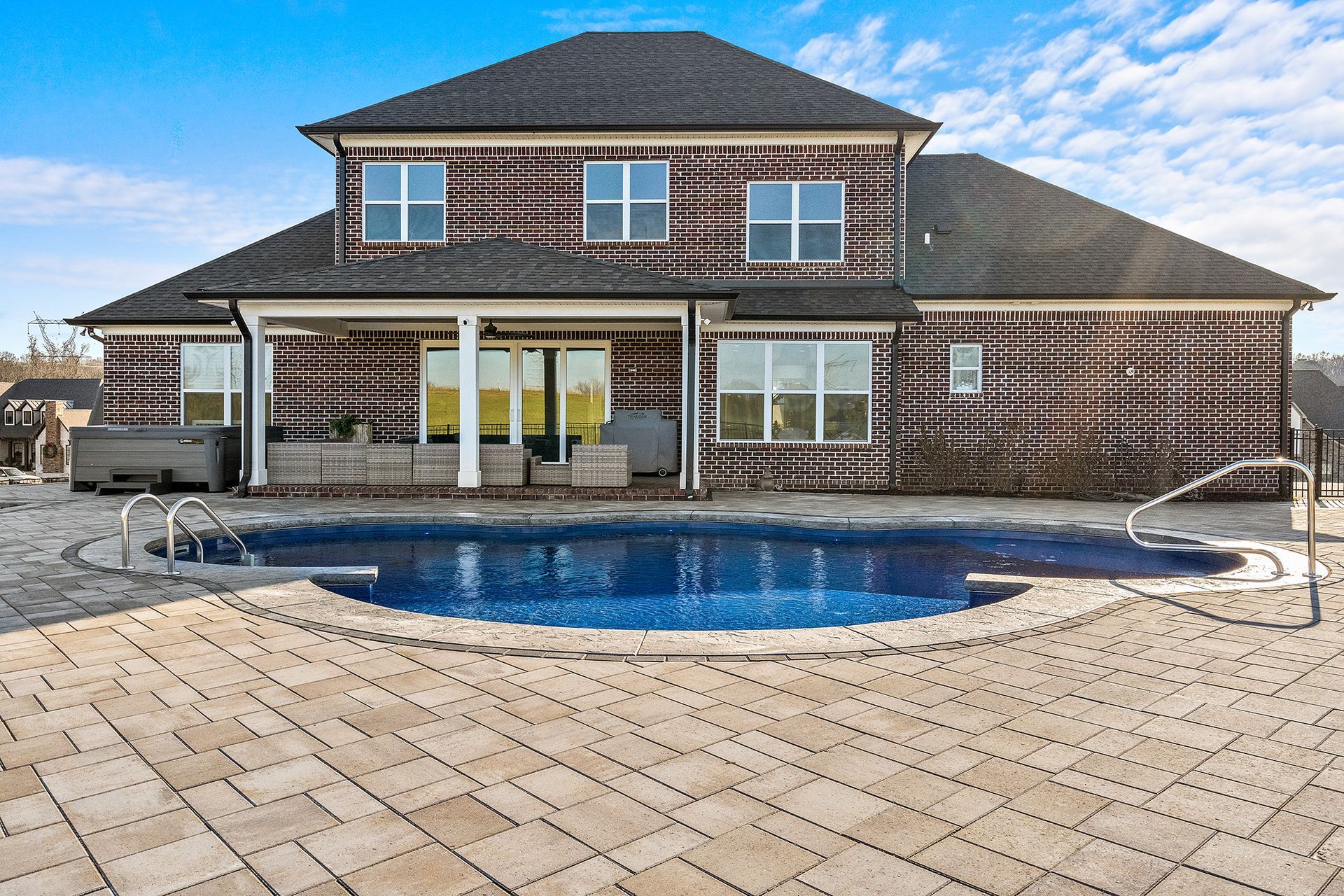 A large house with a large swimming pool in front of it.
