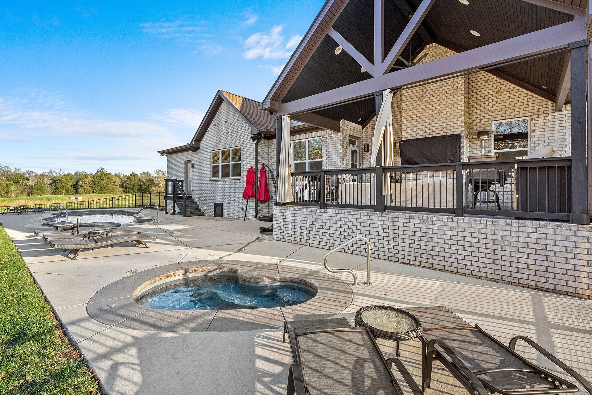 A large house with a covered patio and a hot tub.