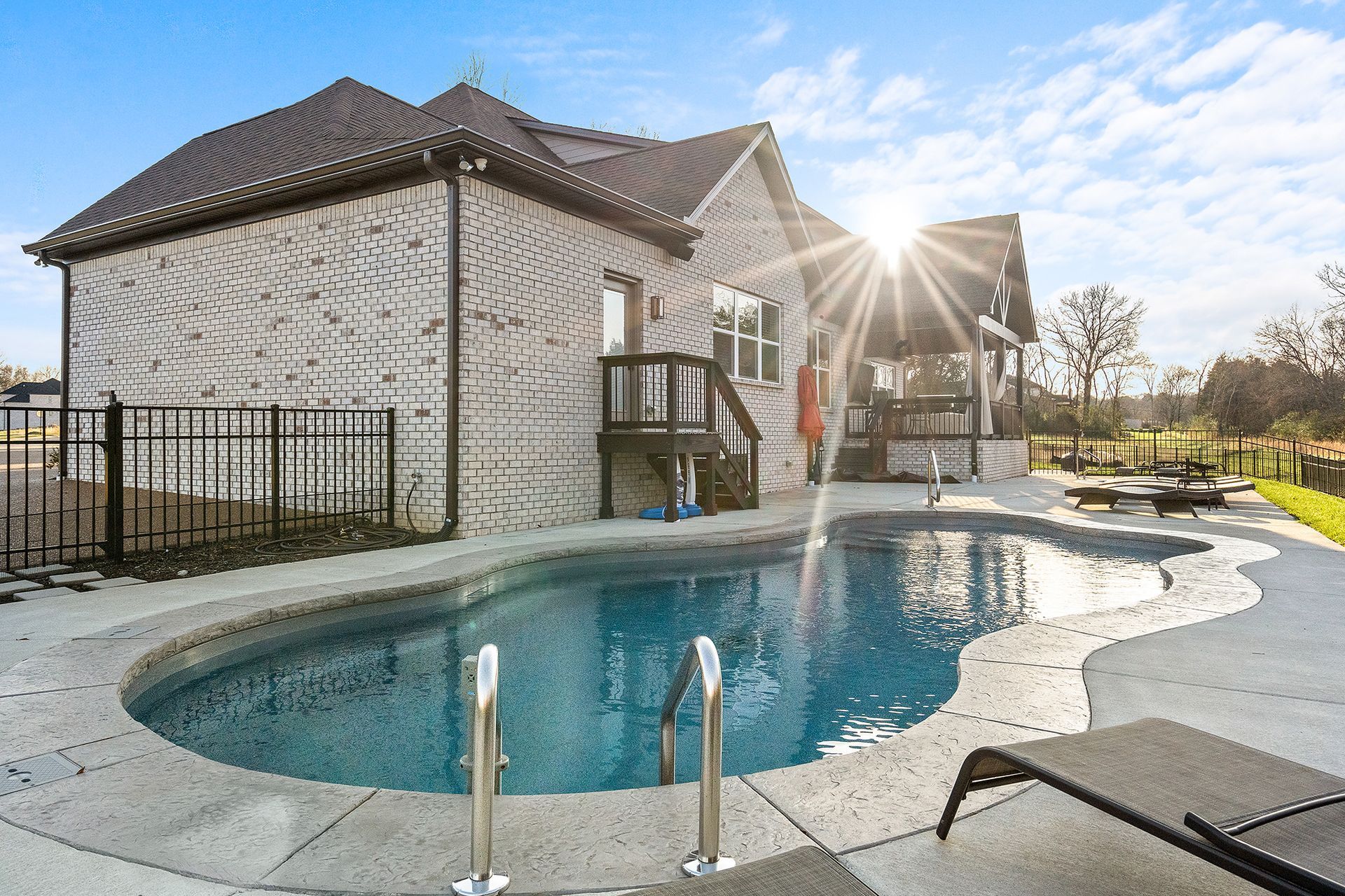 A house with a large swimming pool in front of it