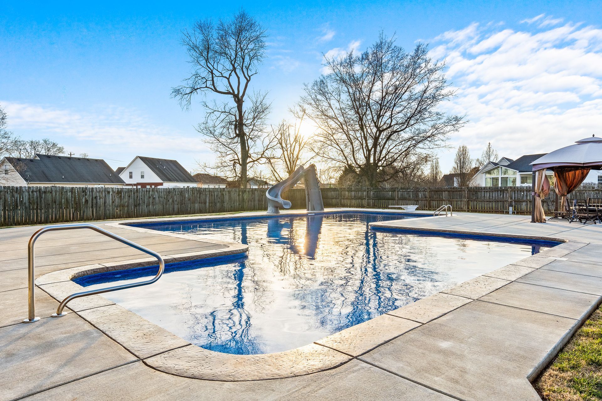 A large swimming pool in the backyard of a house.