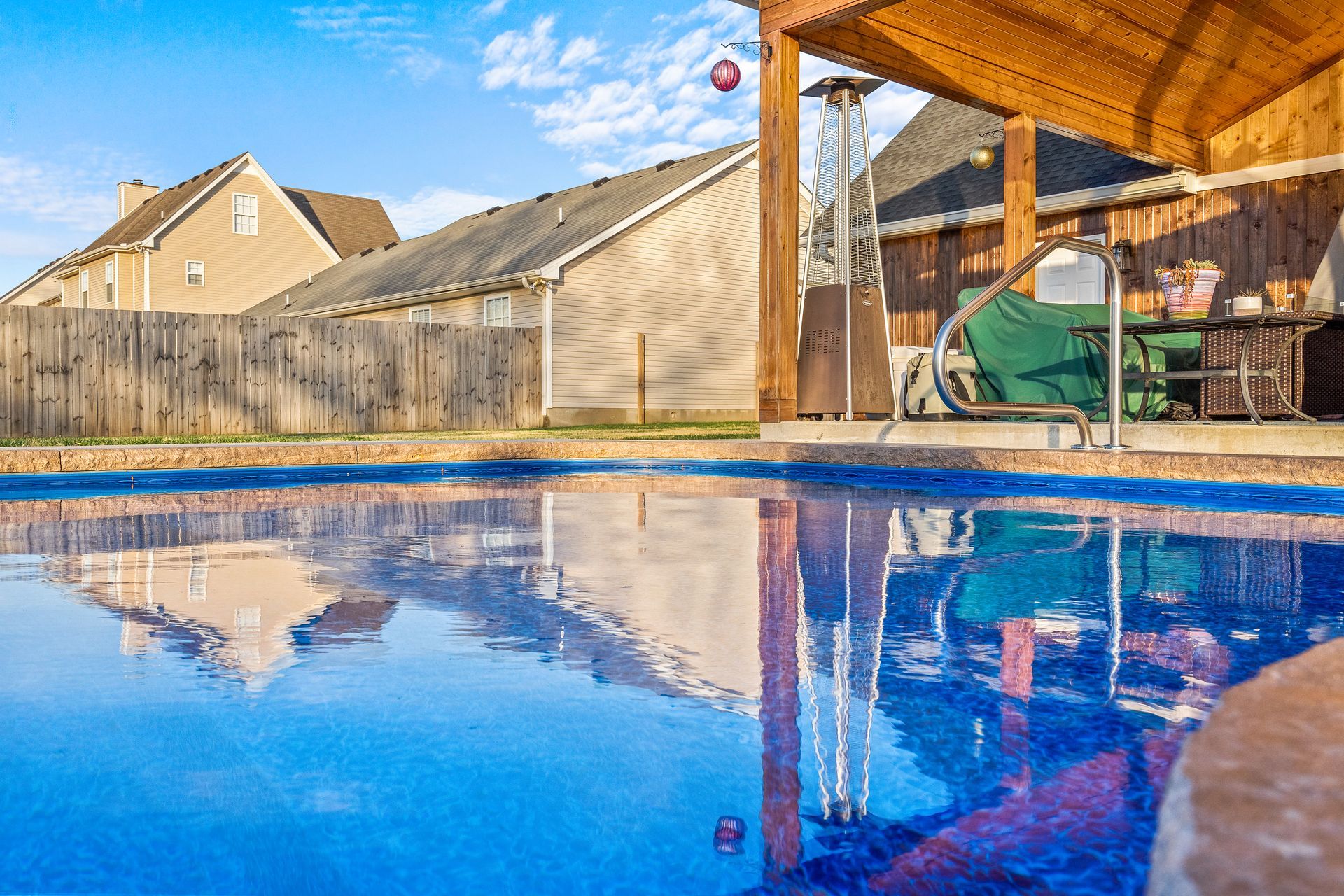 There is a swimming pool in the backyard of a house.