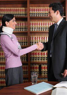 An injured lady shaking hands with the attorney