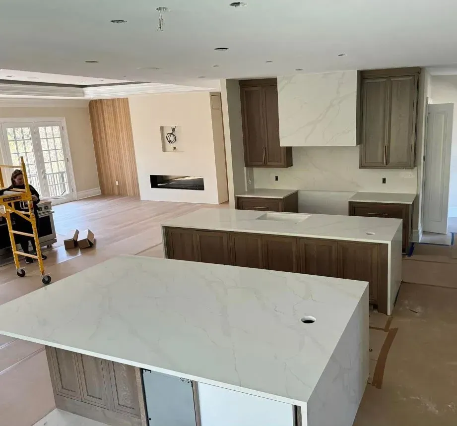 New kitchen under construction, with two islands and built-in cabinets in a large room.