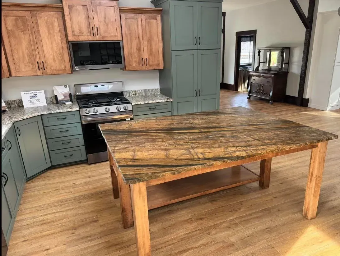 Kitchen with wooden cabinets, island with granite countertop, and gas stove.