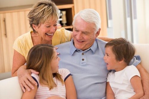 A family is sitting on a couch and laughing together.