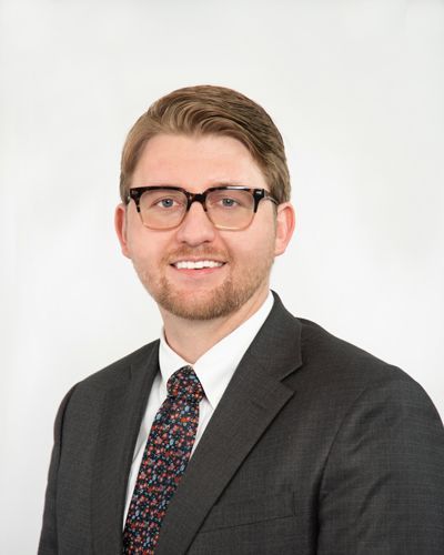 A man in a suit and tie is smiling for the camera.