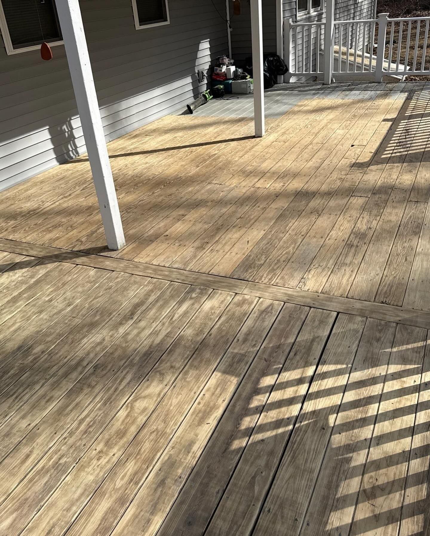 Wooden deck with faded color; sun and shadows.