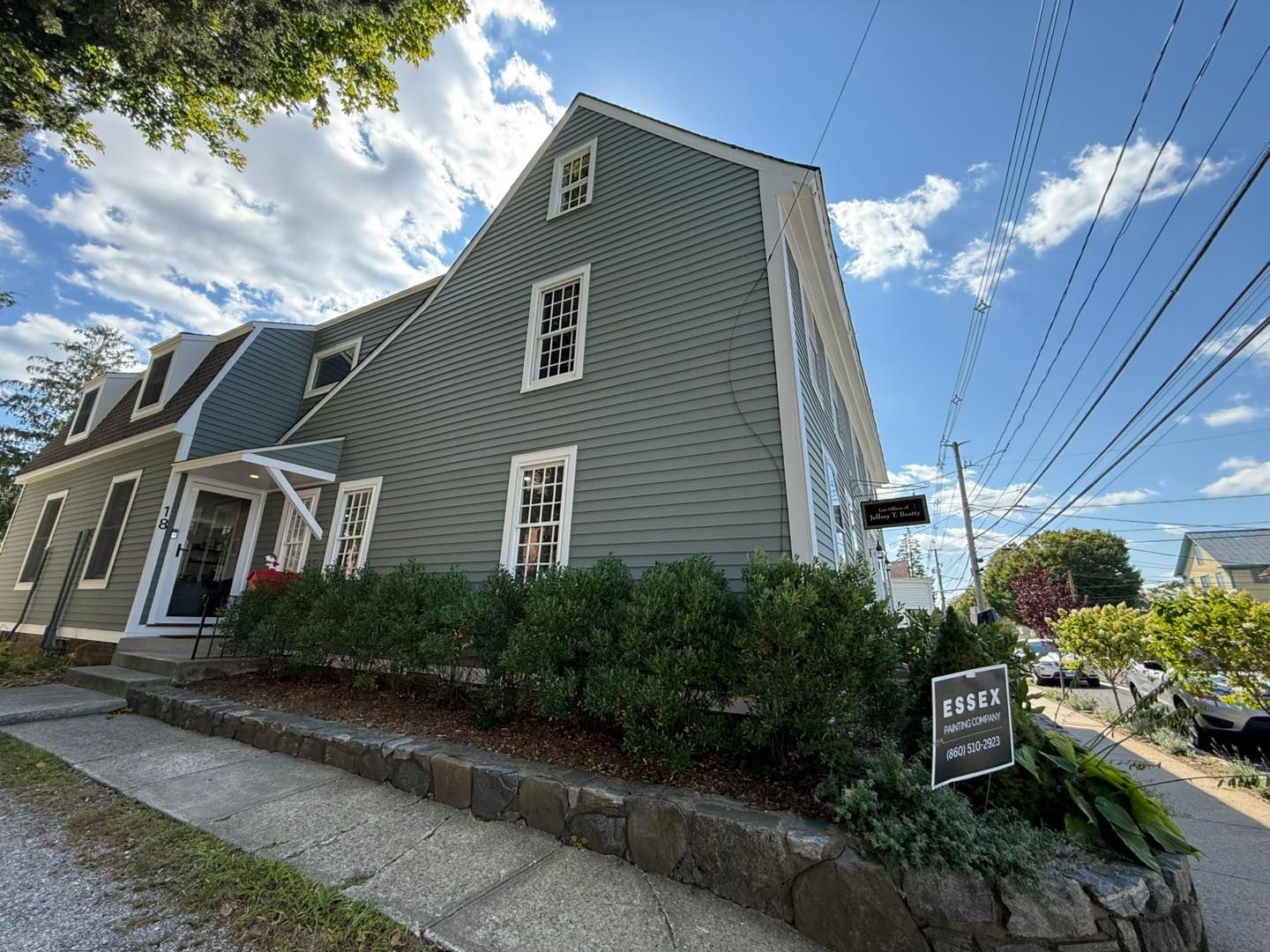 Green building with white trim and a sign that reads.