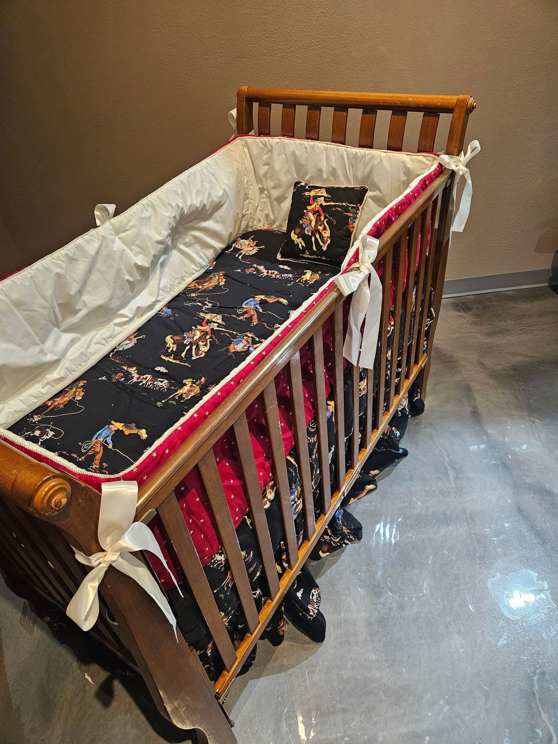 A rustic bedroom set with a wooden bed frame, matching nightstand, and dresser on a gray concrete floor.