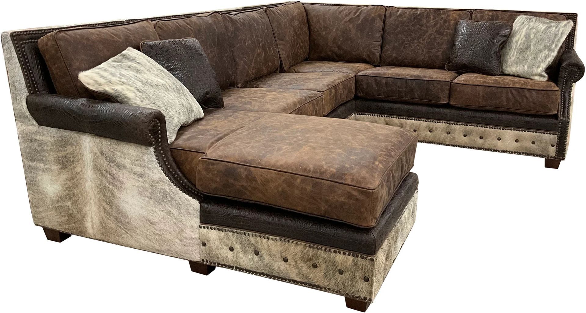 A brown, L-shaped sectional sofa with a cowhide-patterned base and accents, featuring tufted detailing and throw pillows.