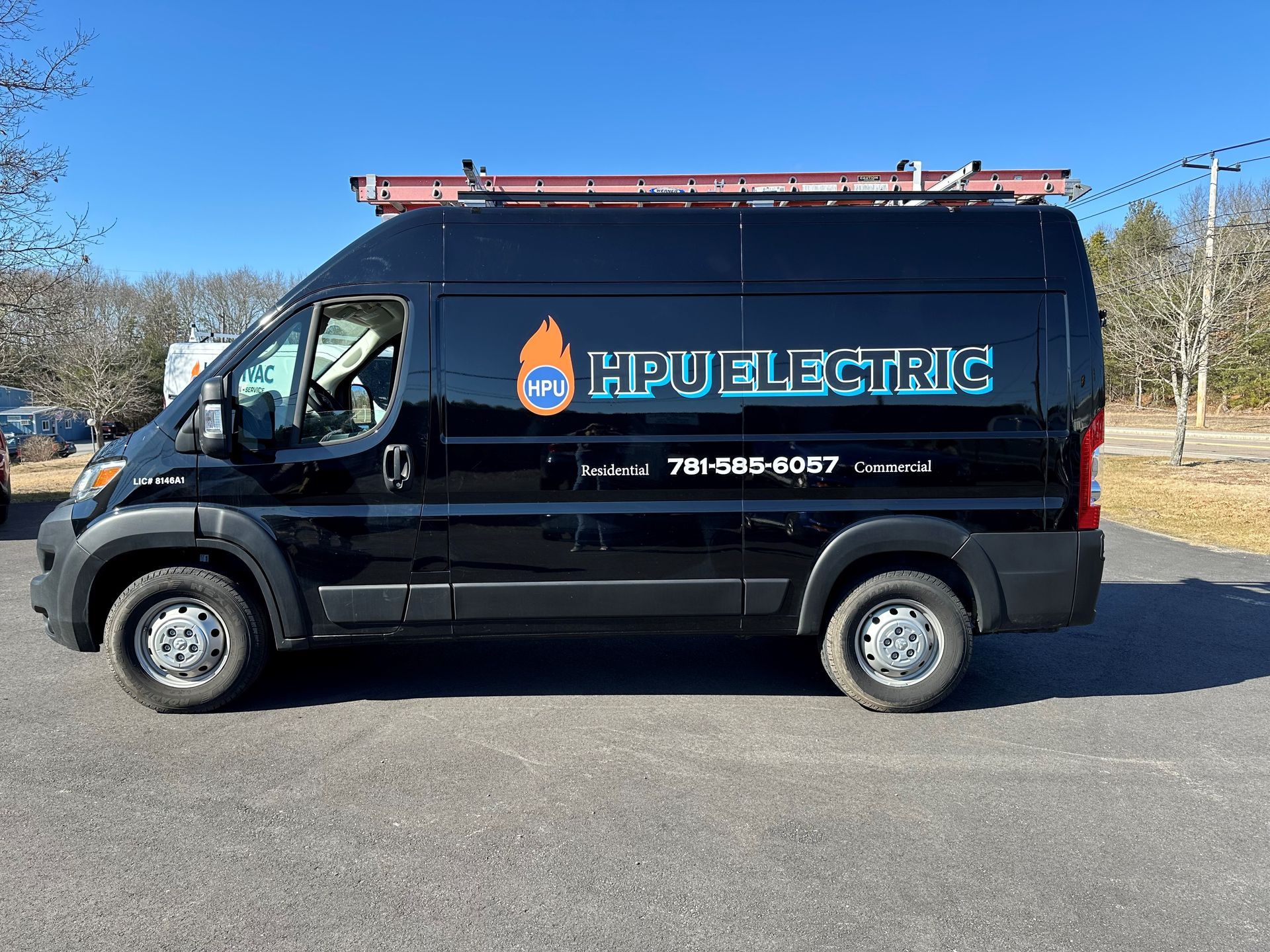 Black Electric van is parked on the side of the road .