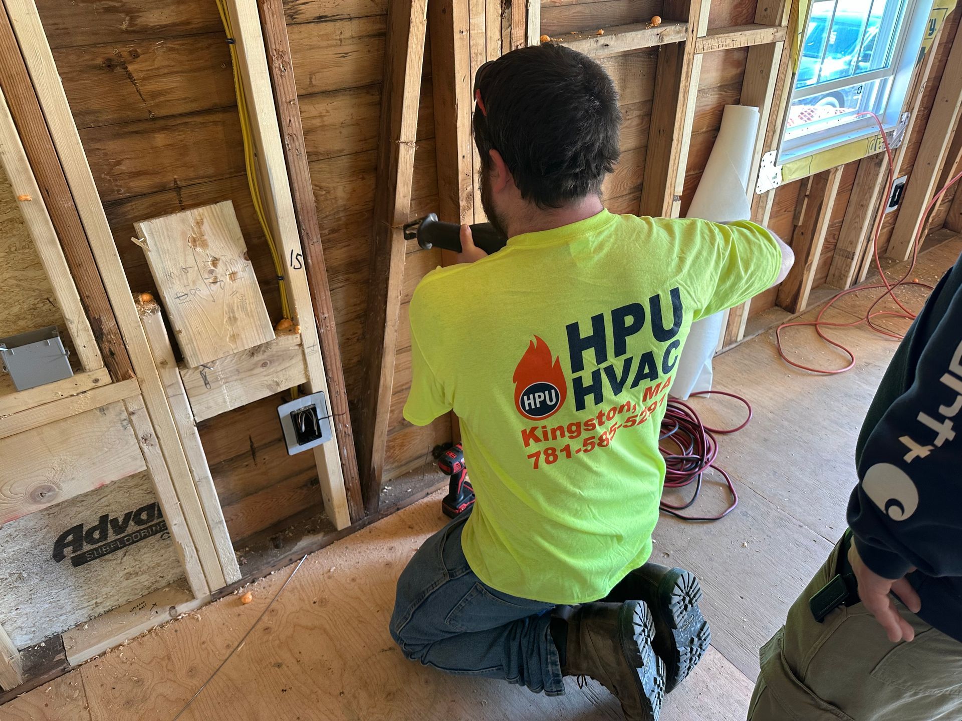 A man is cutting a wall for an air conditioner