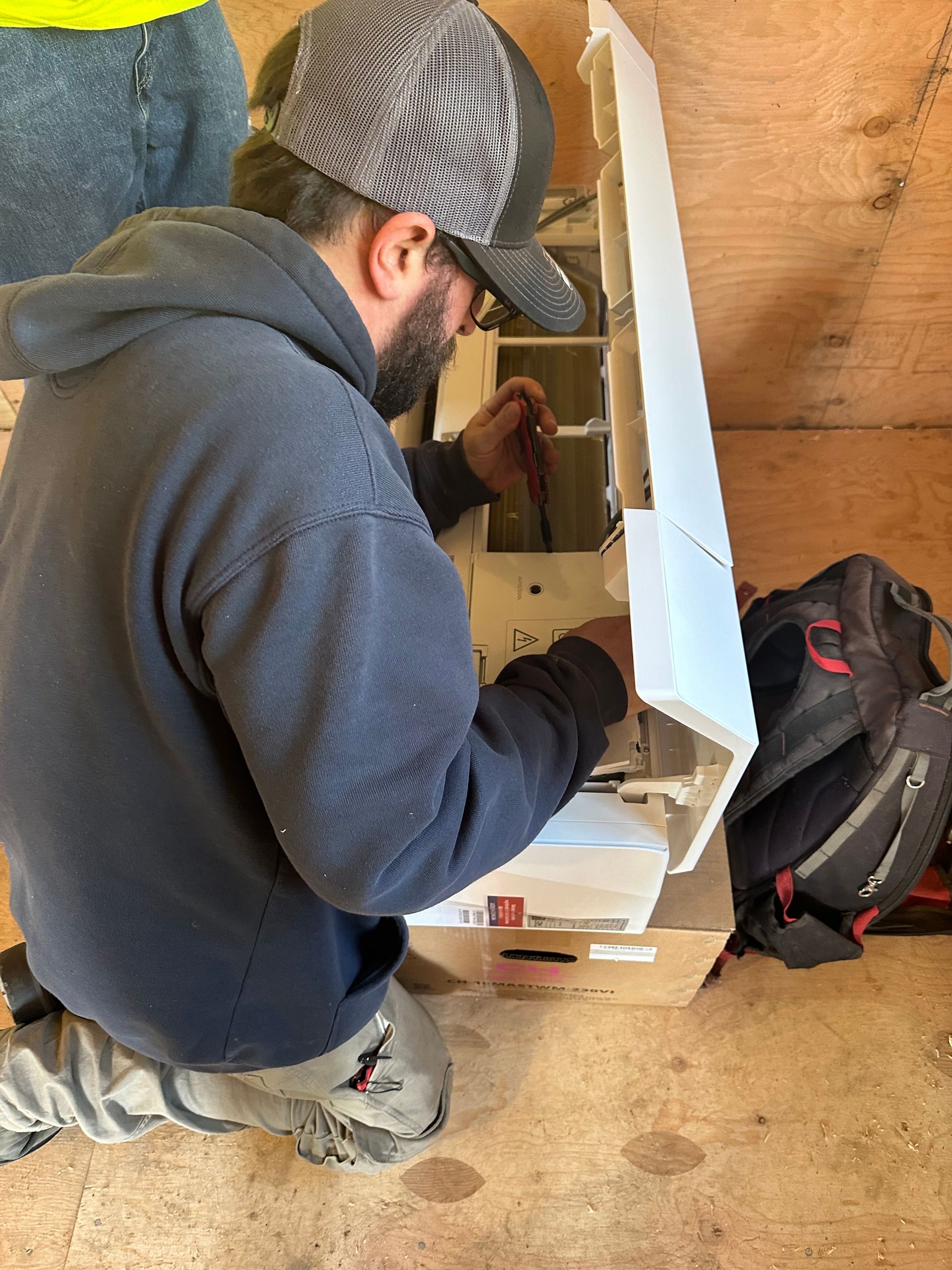 A man is working on an air conditioning system