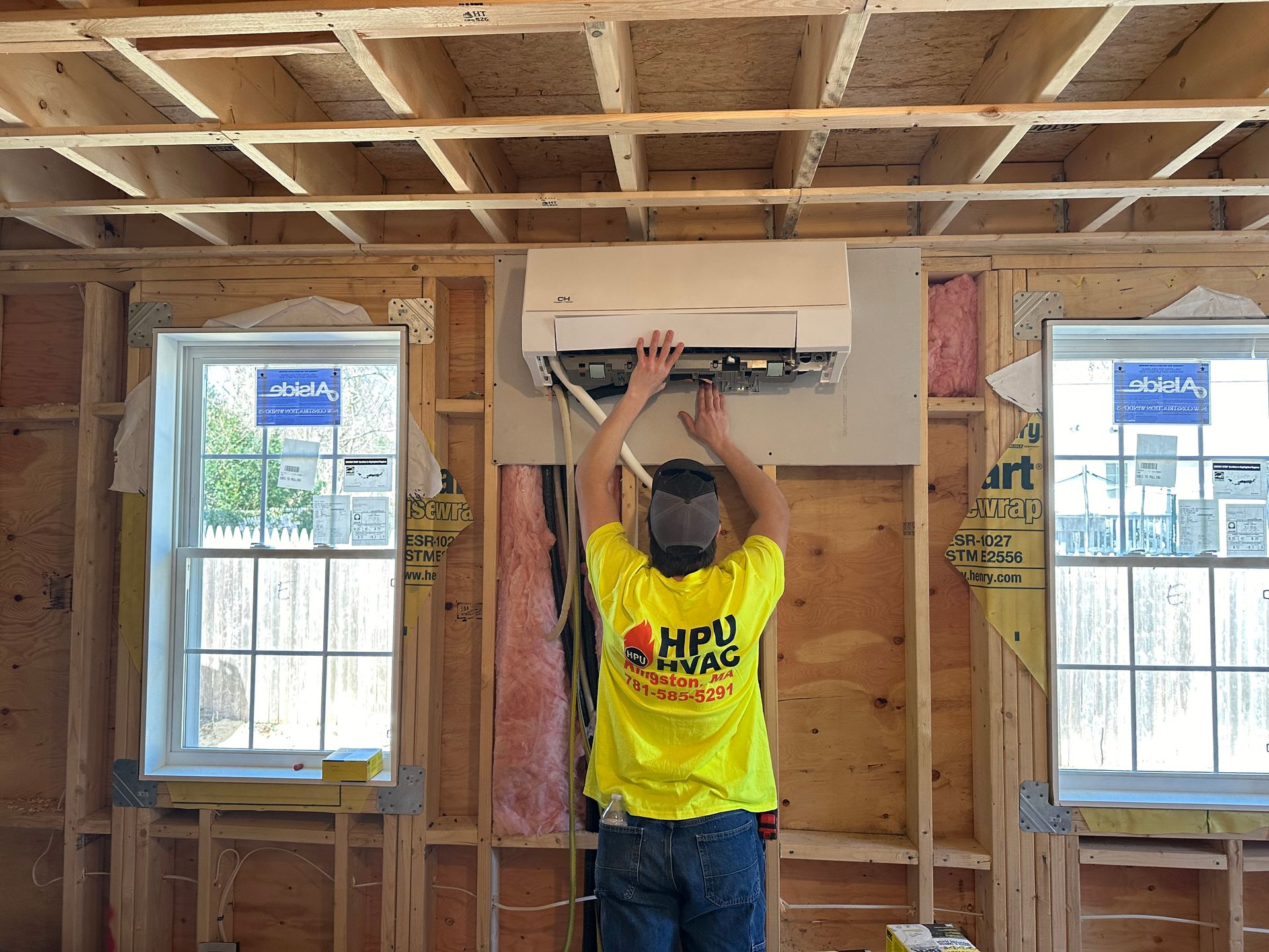 A man installing a wall-mounted air conditioner
