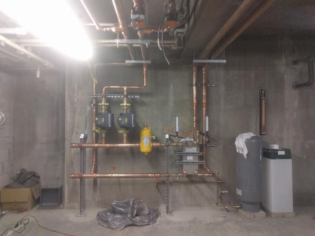 A bunch of white pipes with green valves on them