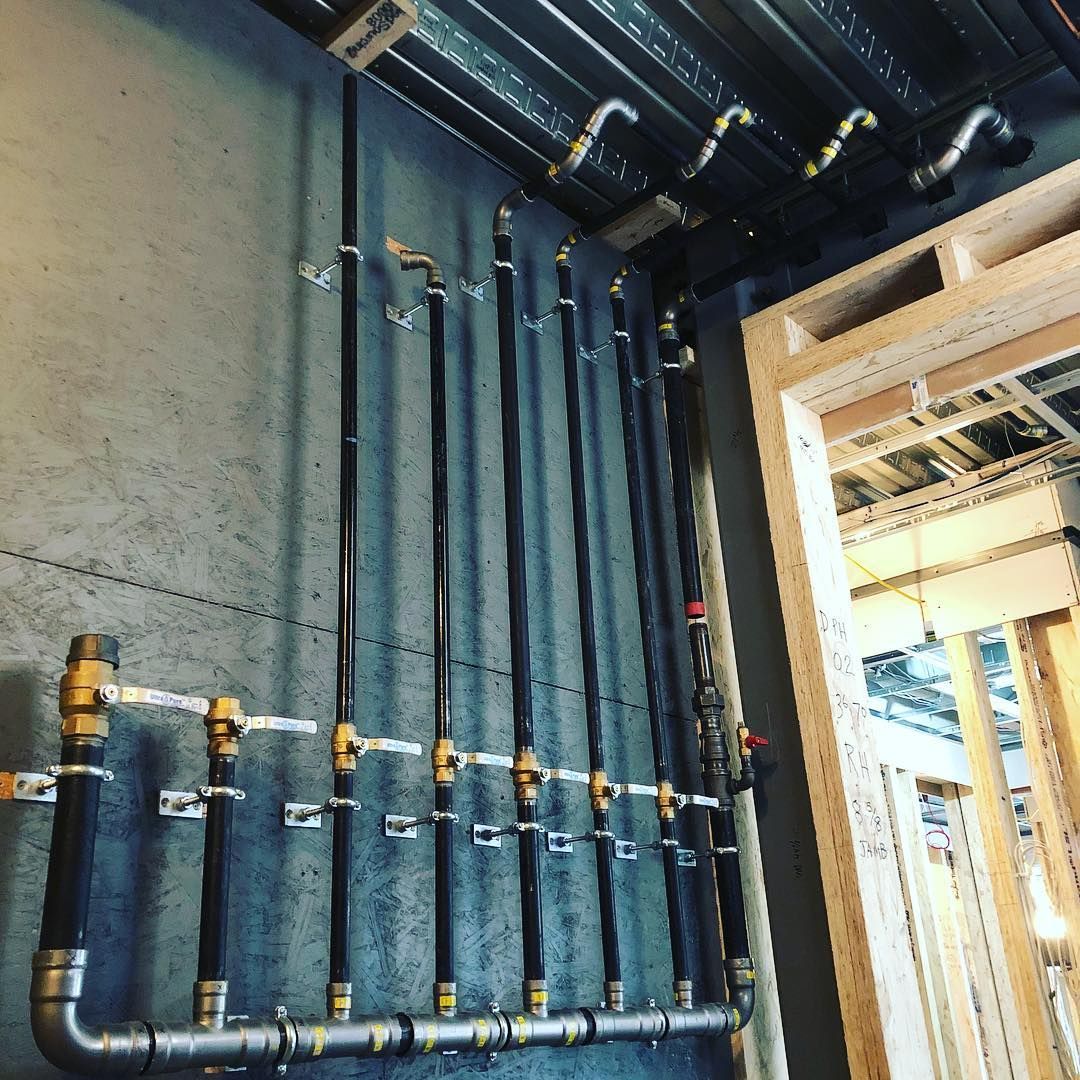 A man standing on a ladder working on a water heater