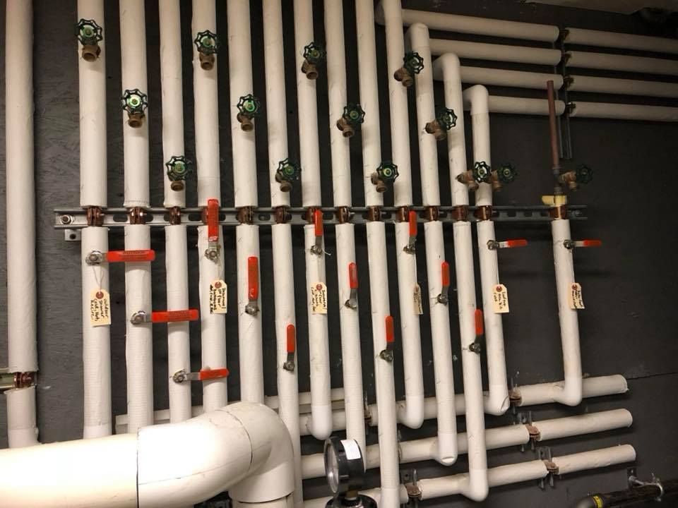 A room with a lot of pipes hanging from the ceiling