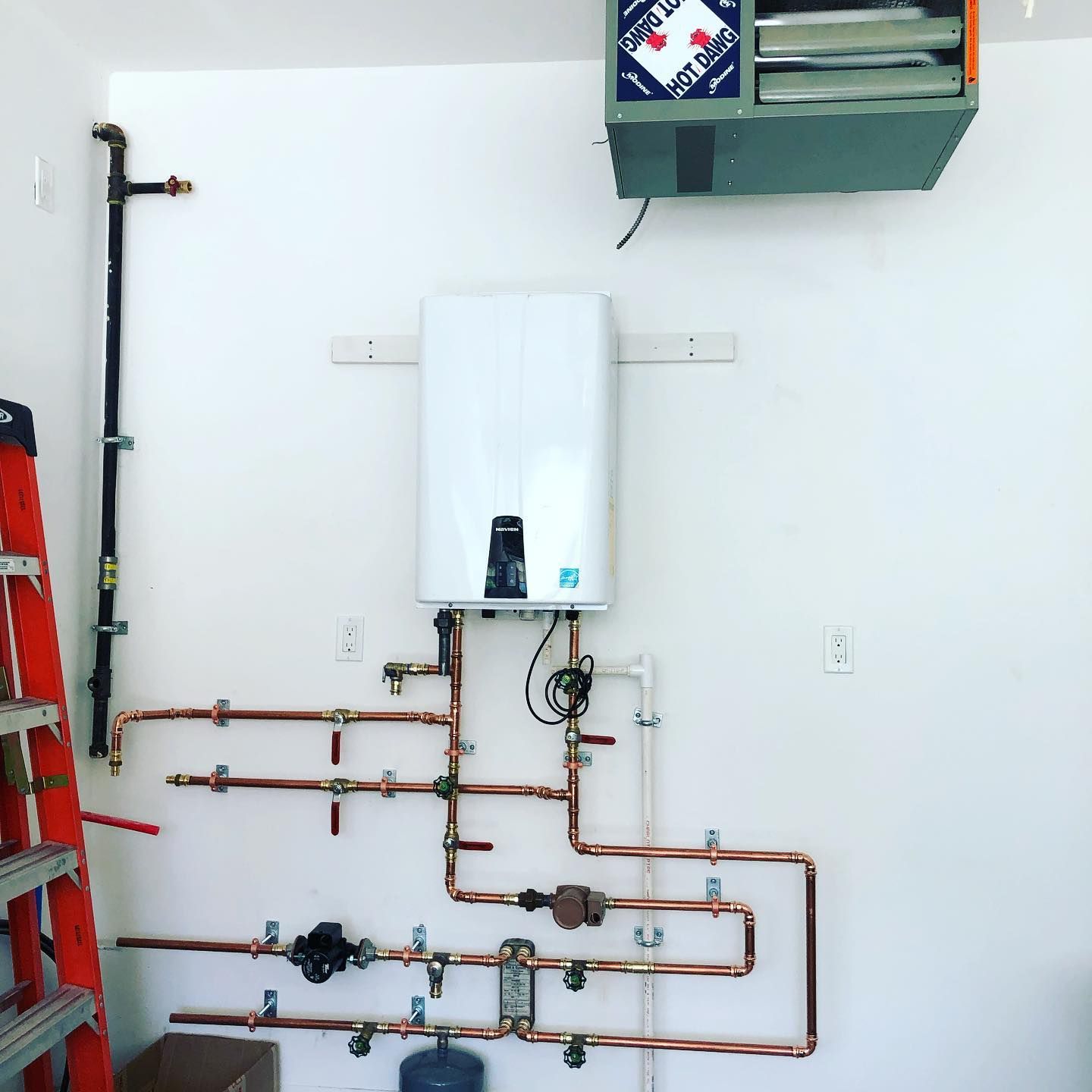 A room with copper pipes and a blue tank