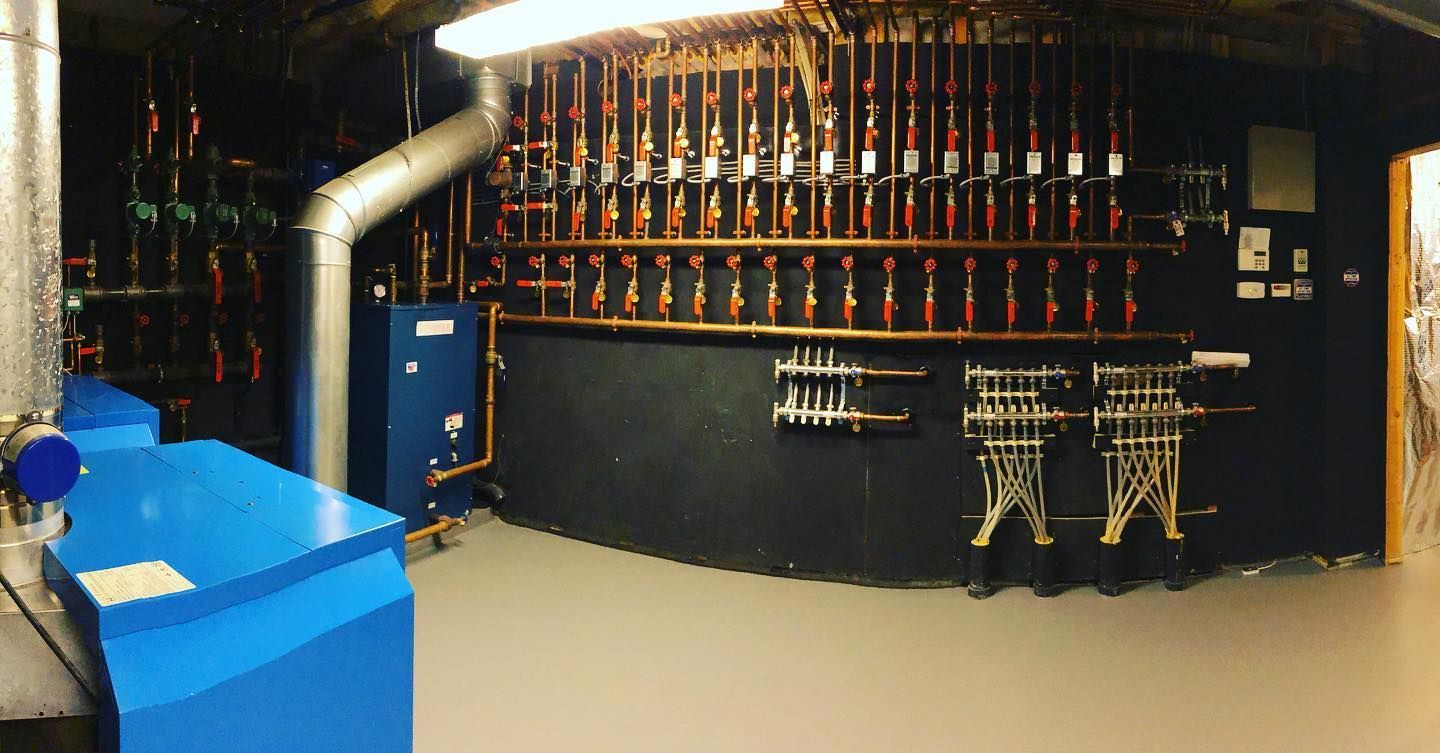 A room with a lot of copper pipes hanging on the wall.