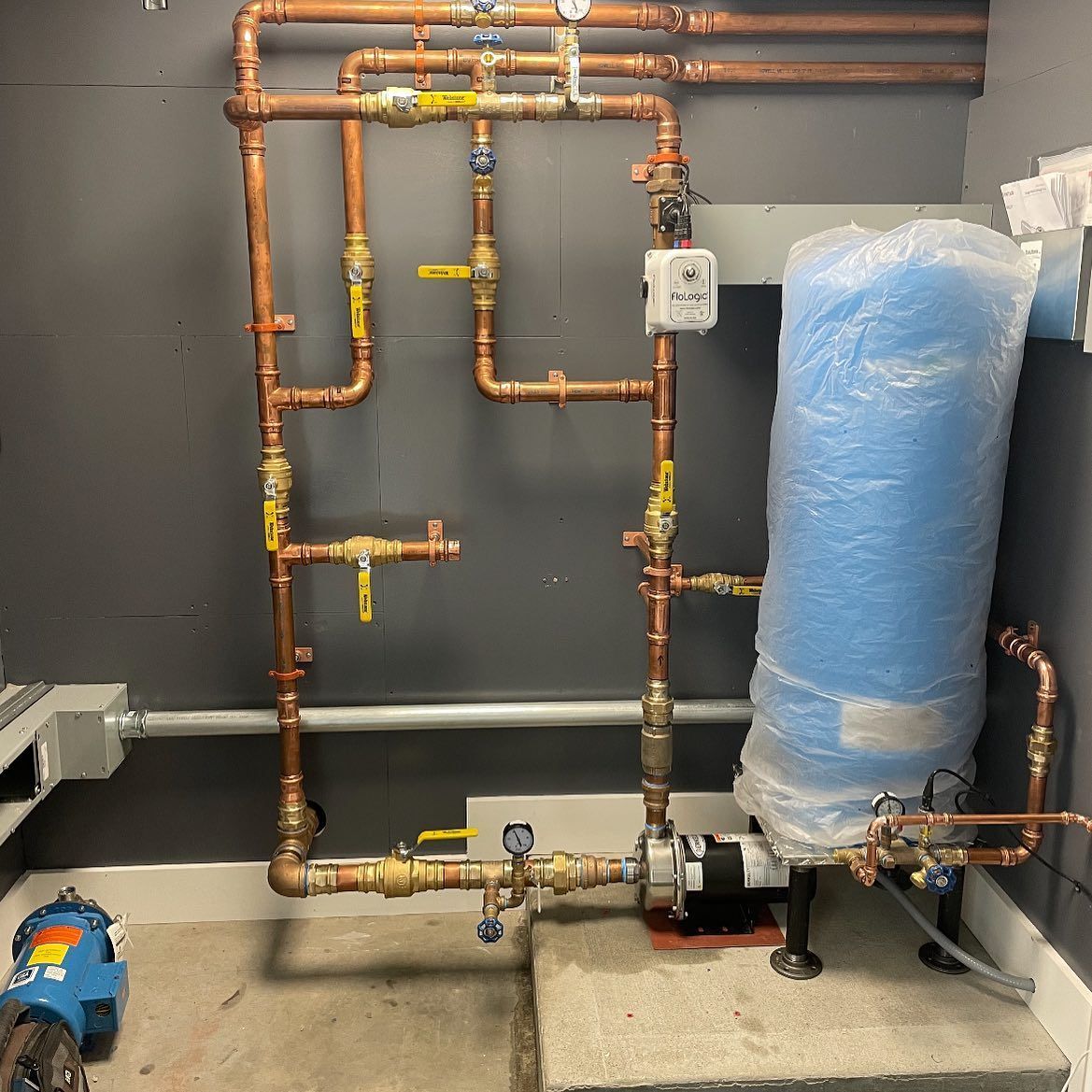 A room with a ladder and a boiler on the wall