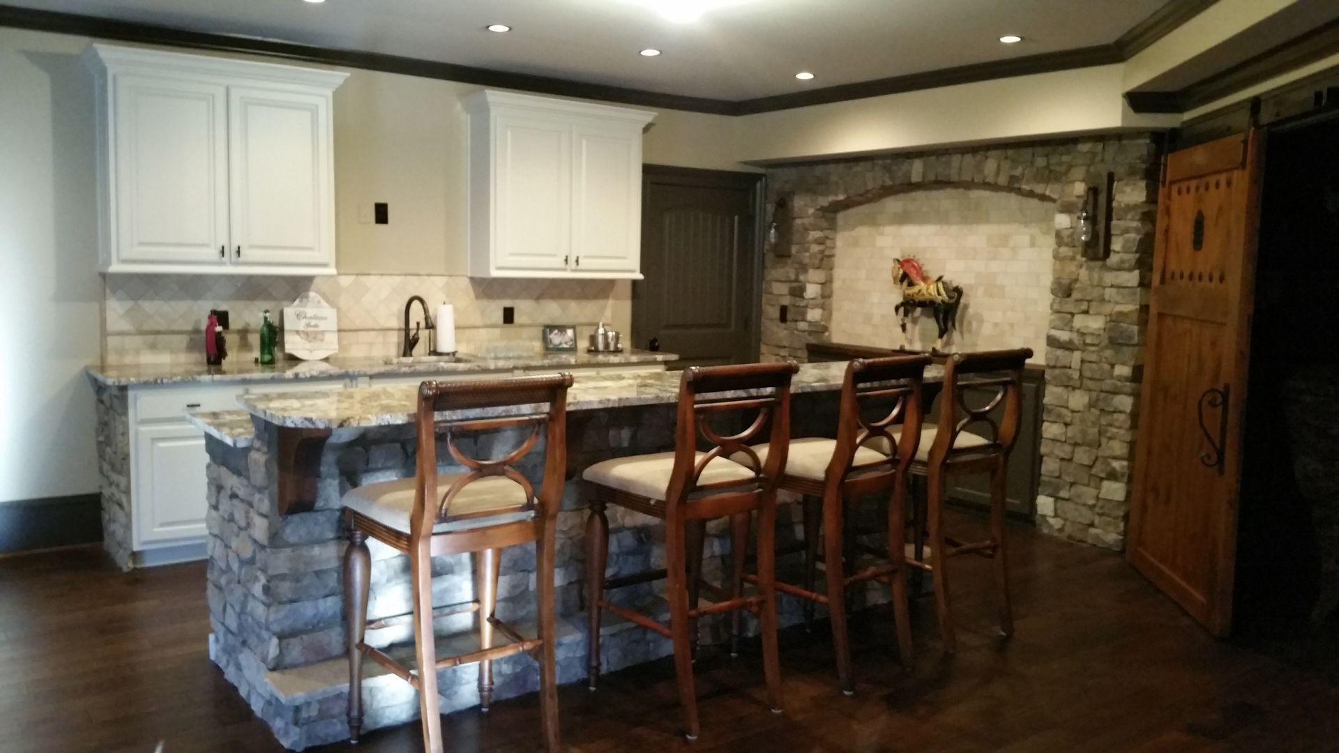 a kitchen with a large island and stools in it