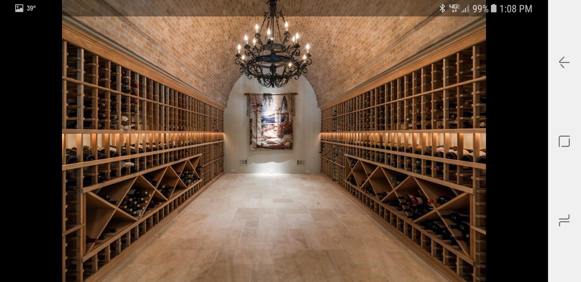 a large wine cellar with lots of shelves and a chandelier .