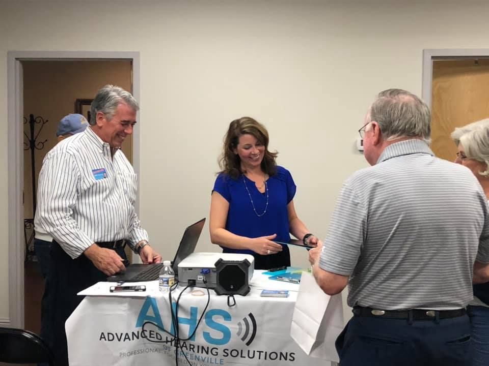 People at a booth labeled 