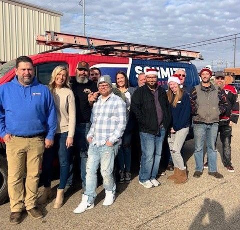 A group of people are posing for a picture in front of a van.