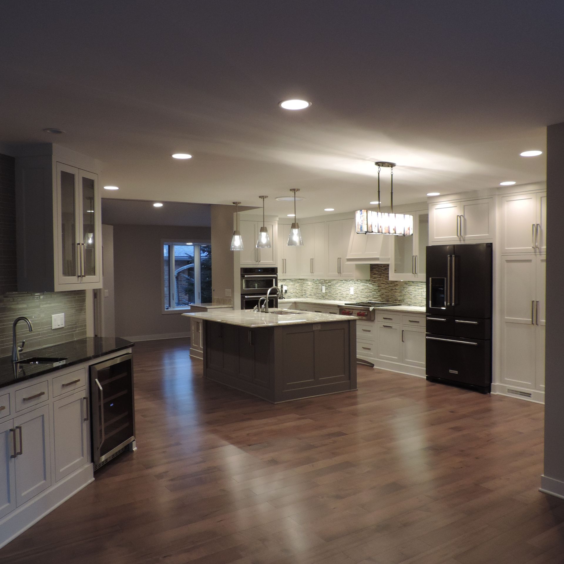 A large kitchen with white cabinets and black appliances
