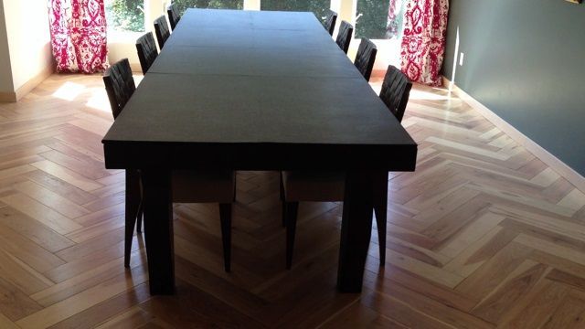 A dining room with a long black table and chairs