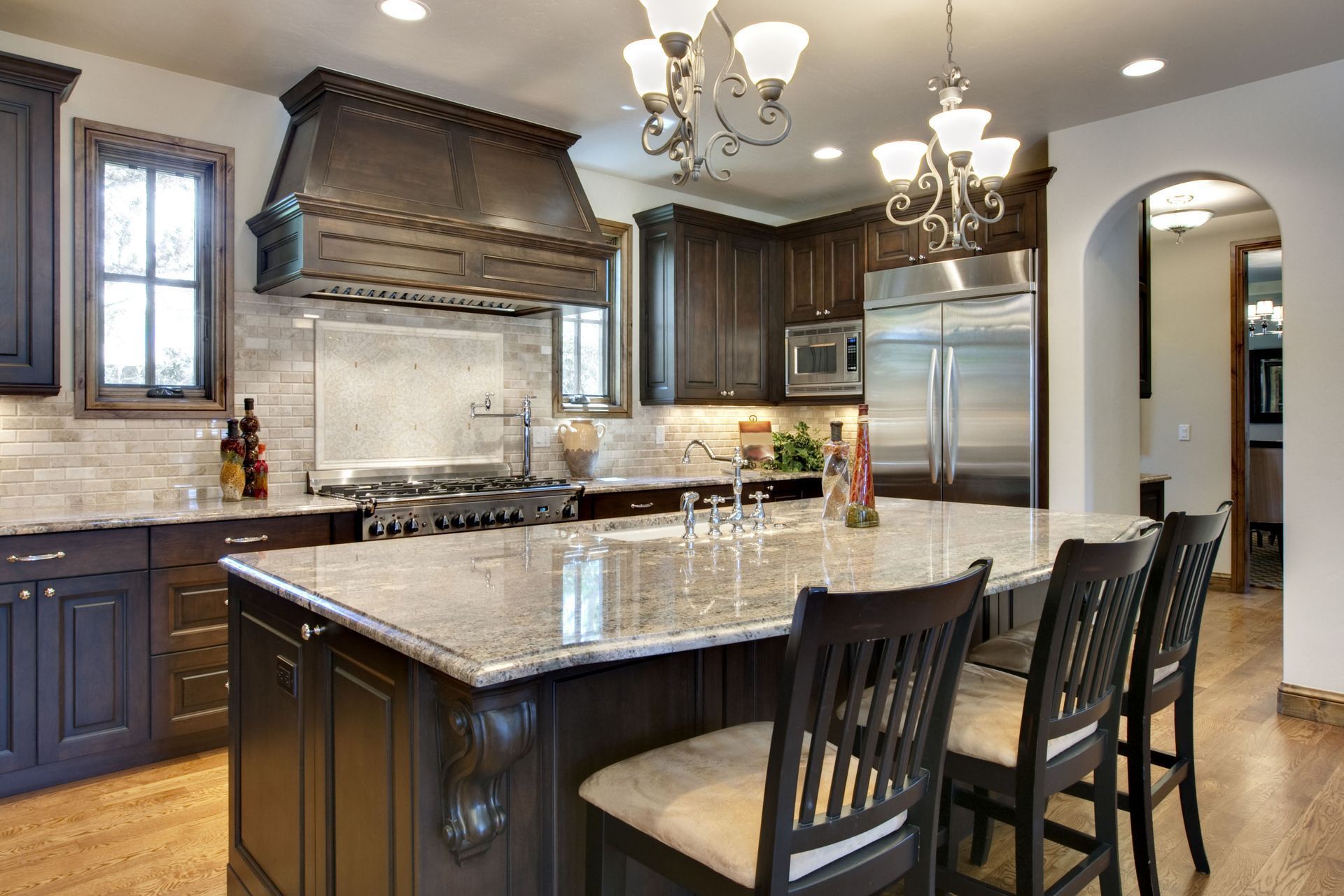Elegant kitchen with dark cabinets, granite countertops, and stainless steel appliances.