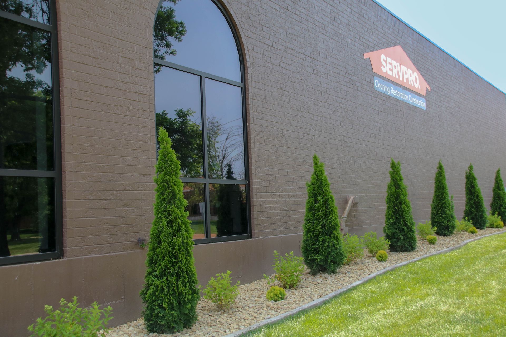 Brown brick building with dark windows; 