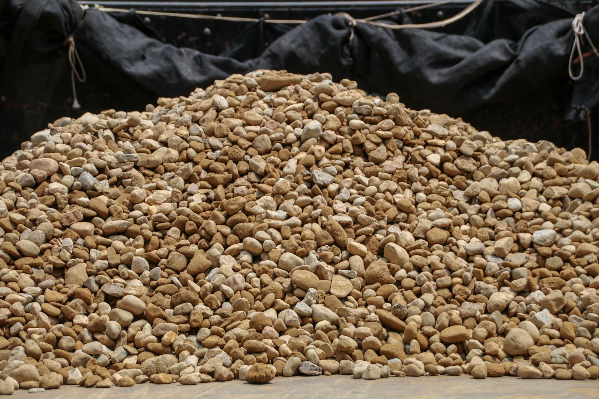 Pile of tan and brown river rocks.