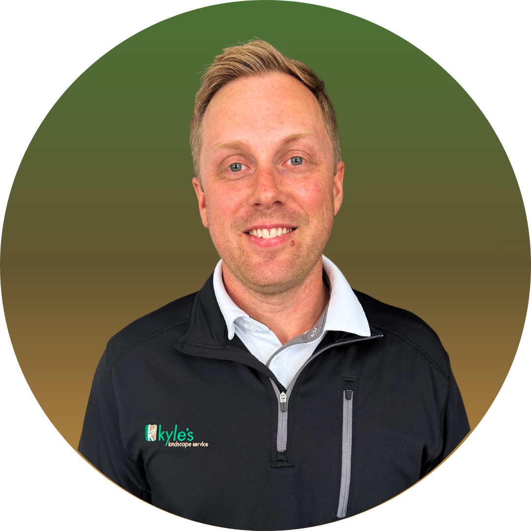 Man in black shirt smiling, logo on shirt, set against a green gradient background.