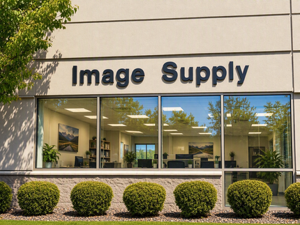 Image Supply storefront with large windows and trimmed bushes outside