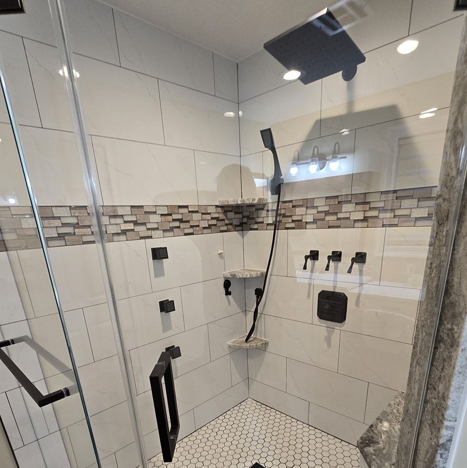A shower with a glass door and a shower head