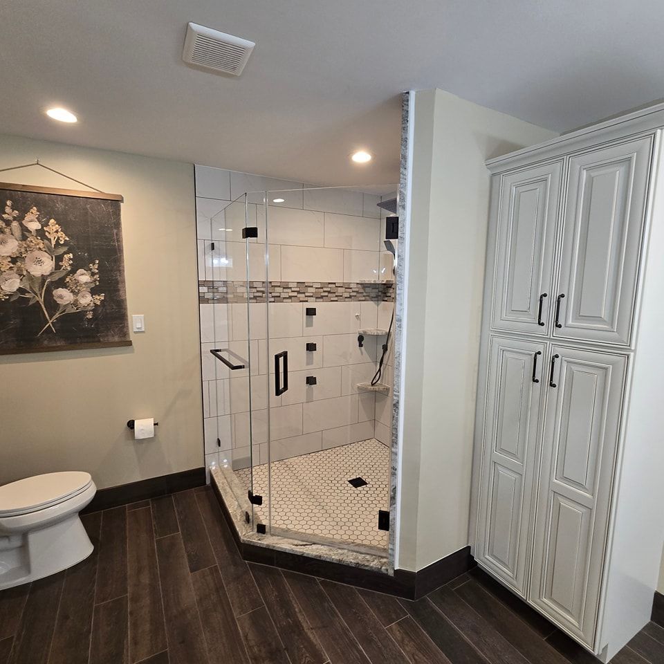A bathroom with a toilet and a walk in shower